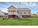 Backyard view showcasing the home's covered porch, brick foundation, and access stairs at 332 Shiloh S Rd, York, SC 29745