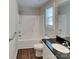 Bright bathroom featuring a shower-tub combo, modern vanity with a dark countertop, and wood-look flooring at 3608 Shadowcrest Dr, Concord, NC 28027