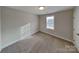 This cozy bedroom has neutral carpeting, a window that lets in natural light, and a white door at 3608 Shadowcrest Dr, Concord, NC 28027
