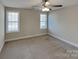 Spacious bedroom with a ceiling fan, two bright windows, and neutral-toned walls at 3608 Shadowcrest Dr, Concord, NC 28027