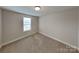 The bedroom features a large window that brings in light and neutral carpeting at 3608 Shadowcrest Dr, Concord, NC 28027
