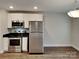 Stylish kitchen features stainless steel appliances, modern white cabinets, and granite countertops at 3608 Shadowcrest Dr, Concord, NC 28027