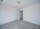 Neutral bedroom with carpet, open closet doors, and white walls at 502 Geneva Cir, Gastonia, NC 28056