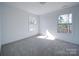 Bright bedroom with neutral carpeting and natural light streaming through two windows at 502 Geneva Cir, Gastonia, NC 28056