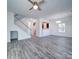 Open-concept living area features modern gray flooring, white walls, and a staircase, creating a bright and airy space at 502 Geneva Cir, Gastonia, NC 28056