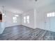 Bright and airy living room with sleek gray flooring, crisp white walls, and ample natural light from large windows at 502 Geneva Cir, Gastonia, NC 28056