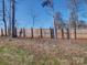 Backyard view with a wooden fence lined with mature trees, offering privacy and a natural backdrop at 554 Geneva Cir, Gastonia, NC 28056