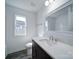 Bathroom with white countertops, dark cabinets, modern fixtures, and wood-look flooring at 554 Geneva Cir, Gastonia, NC 28056