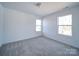 Well-lit bedroom featuring neutral walls, carpet, and a view through two windows at 554 Geneva Cir, Gastonia, NC 28056