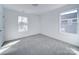 Bedroom features two windows for natural light, neutral colored walls, and carpeted floor at 554 Geneva Cir, Gastonia, NC 28056