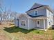 Side view of a two-story home with light-grey siding, a green lawn, a covered porch and bright-white trim at 554 Geneva Cir, Gastonia, NC 28056