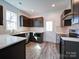 Well-lit kitchen features dark cabinetry, stainless steel appliances, light countertops, and wood-look flooring at 554 Geneva Cir, Gastonia, NC 28056