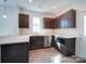 This kitchen features dark cabinets, stainless steel appliances, light countertops, and modern wood-look flooring at 554 Geneva Cir, Gastonia, NC 28056