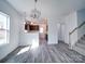 Open-concept living room featuring modern flooring that leads into the kitchen and stairway with carpet at 554 Geneva Cir, Gastonia, NC 28056