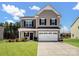 Two-story house with a beige exterior, white garage door, and landscaped lawn at 6351 Trinity Crossing Cir, Kannapolis, NC 28081