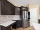 Modern kitchen features dark cabinets, stainless steel appliances, a brick backsplash and sleek countertops at 6351 Trinity Crossing Cir, Kannapolis, NC 28081