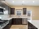 Well-lit kitchen features stainless steel appliances, sleek counter tops and dark cabinets at 6351 Trinity Crossing Cir, Kannapolis, NC 28081