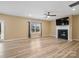 Spacious living room with a fireplace, ceiling fan, and large window overlooking the backyard at 6351 Trinity Crossing Cir, Kannapolis, NC 28081