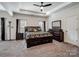 Spacious main bedroom featuring a tray ceiling, ceiling fan, large bed, and elegant decor at 6351 Trinity Crossing Cir, Kannapolis, NC 28081
