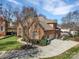 An aerial view of a brick home's exterior, with a spacious driveway, attached garage, and well-kept lawn at 11402 Bloomfield Dr, Charlotte, NC 28277