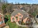 A stunning aerial view of a brick house showcasing its manicured lawn and surrounding neighborhood at 11402 Bloomfield Dr, Charlotte, NC 28277