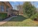 A lovely backyard with a brick patio, screened-in porch, seating area, and mature trees at 11402 Bloomfield Dr, Charlotte, NC 28277