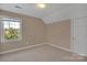 Cozy bedroom with a window offering a view of trees and a white door at 11402 Bloomfield Dr, Charlotte, NC 28277