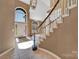 Spacious foyer showcasing tile flooring, an elegant staircase, and ample natural light from large arched windows at 11402 Bloomfield Dr, Charlotte, NC 28277