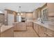 Functional kitchen showcasing a gas cooktop island, ample cabinet space, tiled floors, and stainless steel appliances at 11402 Bloomfield Dr, Charlotte, NC 28277