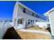 Rear view of the home showcases a backyard with an attached covered patio and white privacy fence at 12712 Wandering Brook Dr, Charlotte, NC 28273