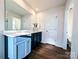 Bathroom featuring a large mirror, modern fixtures, and a vanity with ample storage and wood-look floors at 12712 Wandering Brook Dr, Charlotte, NC 28273