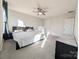 Bedroom featuring a ceiling fan, neutral carpeting and ensuite bath with lots of natural light and a large bed at 12712 Wandering Brook Dr, Charlotte, NC 28273