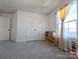 Cozy bedroom with rainbow closet doors, soft gray carpet, and a bright window with yellow curtains at 12712 Wandering Brook Dr, Charlotte, NC 28273