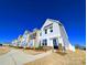 Exterior of modern two-story townhomes with brick and siding, located on a sidewalk at 12712 Wandering Brook Dr, Charlotte, NC 28273