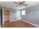 Inviting bedroom featuring hardwood floors, a ceiling fan, and ample natural light from a window at 128 Summerlea Dr, Charlotte, NC 28214