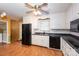 Functional kitchen featuring white cabinets, a black refrigerator, and laminate wood flooring at 128 Summerlea Dr, Charlotte, NC 28214
