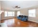 Bright living room featuring hardwood floors, large windows, and a comfortable blue sofa at 128 Summerlea Dr, Charlotte, NC 28214