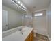 Bathroom featuring a large mirror, spacious countertop, and a combined shower and bathtub at 13410 Tartarian Ct, Charlotte, NC 28215