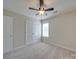 Bright bedroom featuring a ceiling fan, neutral carpet, and large closet at 13410 Tartarian Ct, Charlotte, NC 28215