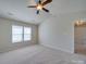 Spacious bedroom with a ceiling fan, neutral carpet, and plenty of natural light at 13410 Tartarian Ct, Charlotte, NC 28215