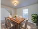 Well-lit dining room featuring wood floors, table set for six, and a plant near a window at 13410 Tartarian Ct, Charlotte, NC 28215