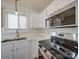 Bright kitchen featuring white cabinets, stainless steel appliances, and a double sink at 13410 Tartarian Ct, Charlotte, NC 28215