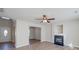 Open-concept living area featuring neutral walls, wood-look flooring, fireplace, and a ceiling fan at 13410 Tartarian Ct, Charlotte, NC 28215
