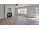 Spacious living room with hardwood floors, fireplace, ceiling fan, and bright windows at 13410 Tartarian Ct, Charlotte, NC 28215