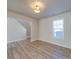 Open living room with wood flooring, bright window, and stairs visible at 13410 Tartarian Ct, Charlotte, NC 28215