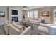Bright living room with fireplace, ceiling fan, neutral tones, and large windows with stylish furnishings at 13410 Tartarian Ct, Charlotte, NC 28215