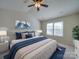 Cozy main bedroom showcasing a large bed, blue accents, wall art, and a window at 13410 Tartarian Ct, Charlotte, NC 28215