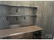 This bar area features wood paneling, a granite countertop, open shelving, and base cabinets at 135 Waycross Dr, Rockwell, NC 28138