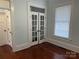 The bedroom features gleaming hardwood floors, white trim, light blue walls, and interior French doors at 135 Waycross Dr, Rockwell, NC 28138