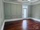 Bedroom featuring hardwood floors, painted paneling, and a door to the outside at 135 Waycross Dr, Rockwell, NC 28138